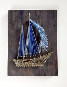 a wooden plaque with a blue sailboat on it