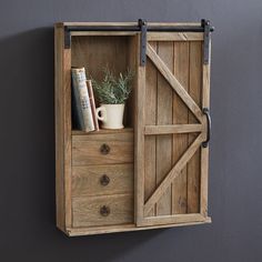 a wooden shelf with books and a potted plant in it on top of a wall