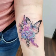 a woman's arm with a butterfly and flowers tattoo on the left side of her arm