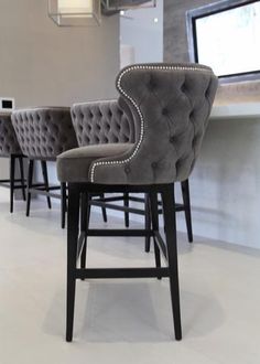 three gray chairs sitting next to each other in front of a counter with a window