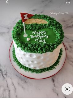 a birthday cake decorated with green grass and a golf flag on top that says happy birthday to you