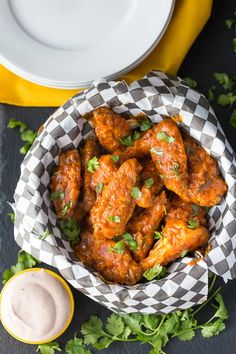 a bowl filled with chicken wings and sauce