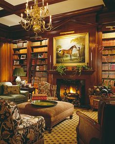 a living room filled with lots of furniture and a fire place under a chandelier