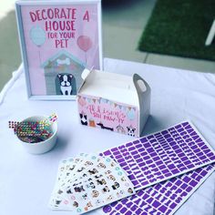 a table topped with lots of stickers next to a box filled with confetti