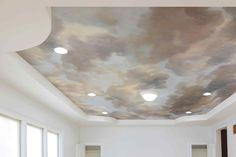 the ceiling is painted with clouds and lights in this living room, as well as two couches