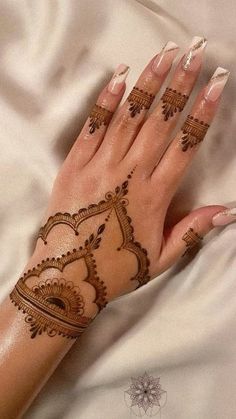 a woman's hand with henna tattoos on it