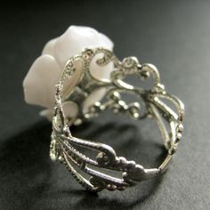 "Bright white resin has been used to create a delicate handmade resin rose that has then been set upon an adjustable filigree ring base in this pretty handmade flower ring that is designed to be adjustable from size 6 and up. Flower Size: 19mm To see this ring in all available colors, check here: http://etsy.me/1gr9dLc The base for this delicate rose ring is adjustable, which makes this handmade flower ring comfortable no matter the size of the wearer's fingers (size 6 and up) as well as ideal f Elegant White Adjustable Flower Ring, Delicate Adjustable White Flower Ring, Delicate White Adjustable Flower Ring, Adjustable Rose Design Jewelry Ring, Handmade Elegant Resin Rings, Elegant Handmade Resin Rings, Elegant Resin Jewelry For Wedding, Vintage Adjustable White Flower Ring, Elegant Handmade White Flower Ring