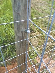 an old wooden post is attached to a wire fence