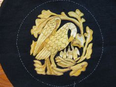 a black hat with gold embroidered eagle on it