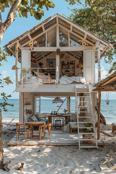 a small house on the beach with stairs leading up to it's second floor