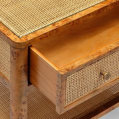 a wooden table with wicker drawers on it's sides and one drawer open