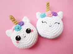 two crocheted unicorn slippers on a pink surface