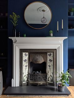 a living room with a fireplace, mirror and potted plants on the mantel