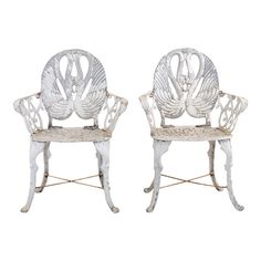 two white painted chairs sitting next to each other