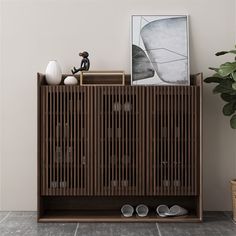 a wooden cabinet sitting next to a potted plant