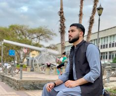 a man sitting on top of a wooden bench