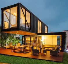 a house made out of shipping containers is lit up at night