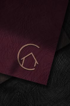 a close up of a red cloth with a house symbol on it and a black background