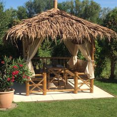 a wooden gazebo sitting on top of a lush green field