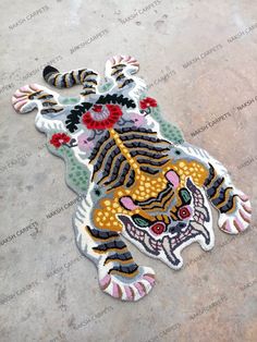 an embroidered patch with a tiger on it's face and flowers in the middle