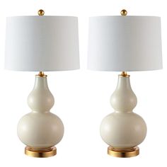 two white ceramic lamps with gold bases