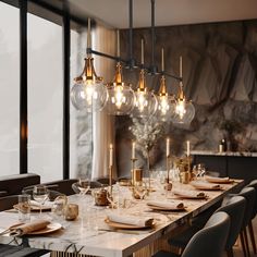 a dining room table with many lights hanging from it's sides and place settings on the tables