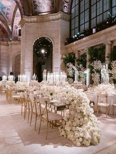 the tables are set with white flowers and candles