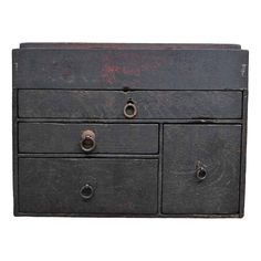 an old black dresser with three drawers and two knobs on each drawer, against a white background