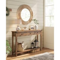 a wooden table sitting in front of a mirror on top of a wall next to a rug