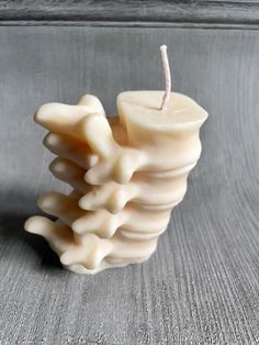 a white candle sitting on top of a wooden table