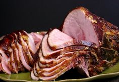 sliced ham on a green platter with other meats