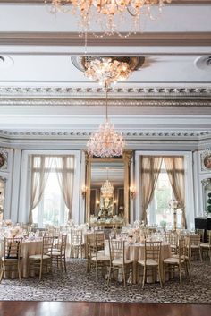 an elegant ballroom with chandeliers and tables