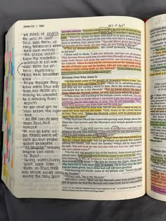 an open bible book with colorful text on the page and in it's center