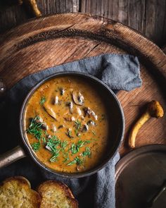 a bowl filled with soup next to some bread