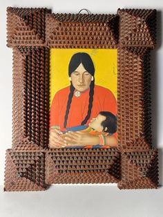 an image of a woman holding a child in her arms with the frame made out of wood