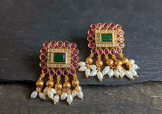 Adorn your ears with these classic squared shape ruby stud earrings with cz and emerald stones in matter gold finish Width: 1 Inches Length: 1.5 Inches Indian Stud Earrings, Gold Buttalu, Big Stud Earrings, Ruby Stud Earrings, Ruby Earrings Studs, Gold Earrings Models, Designer Outfits, Gold Earrings Designs, Stone Studs