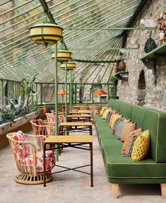 an outdoor seating area with lots of chairs and tables in front of a glass roof