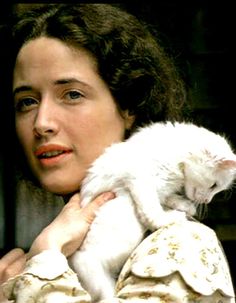 a woman holding a white cat in her arms