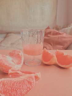 an image of grapefruits on a table with a glass full of water