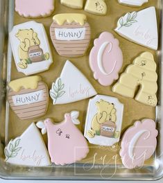 baby shower cookies are arranged in a plastic tray with the letters and numbers on them