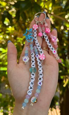 a person is holding some beads in their hand with the words, love and peace written on them