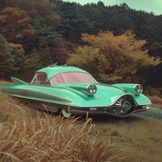 a green car parked on the side of a road in front of some tall grass