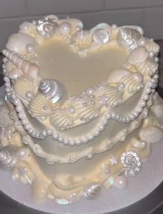 a heart shaped cake with seashells and pearls