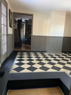 an empty room with black and white checkered flooring