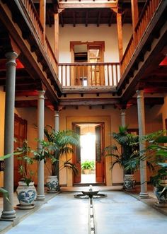 an indoor courtyard with potted plants and columns