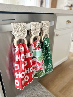 three kitchen towels hanging from the handle of an appliance