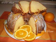 an orange bundt cake on a white plate with sliced oranges and two slices