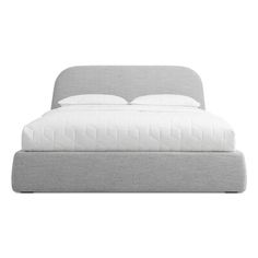 an upholstered bed with white sheets and pillows