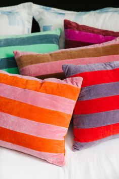 four colorful striped pillows stacked on top of each other