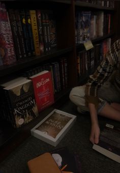 a person sitting on the floor in front of books